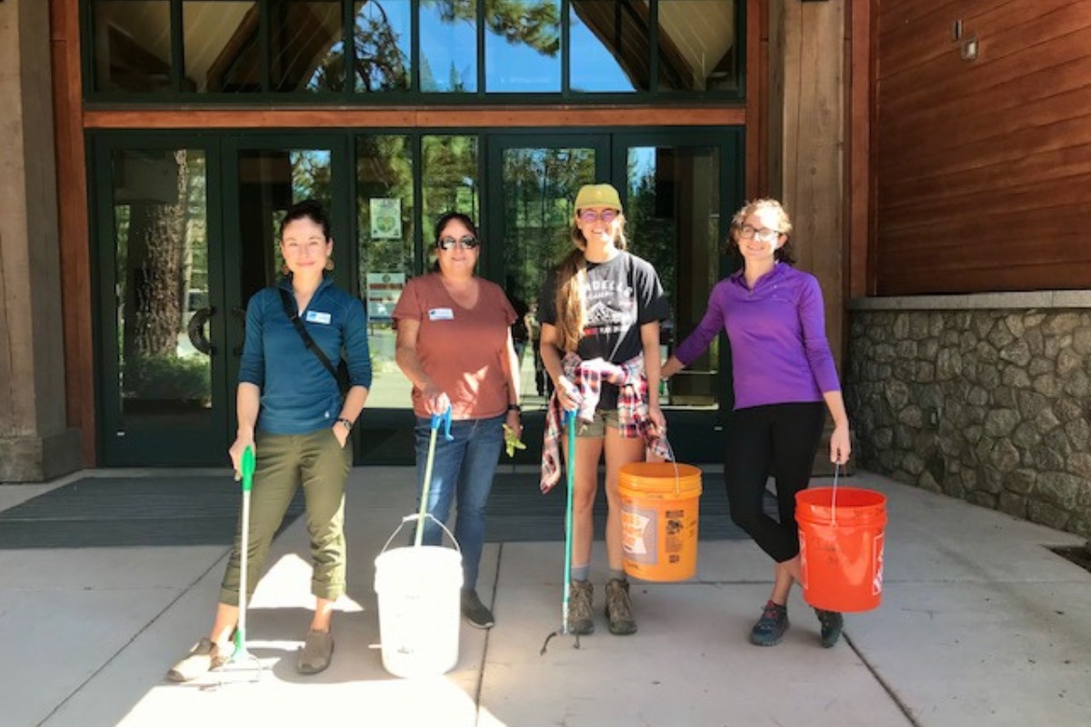 Group of people with trash collecting supplies outside of Donner Memorial State Park visitor center.