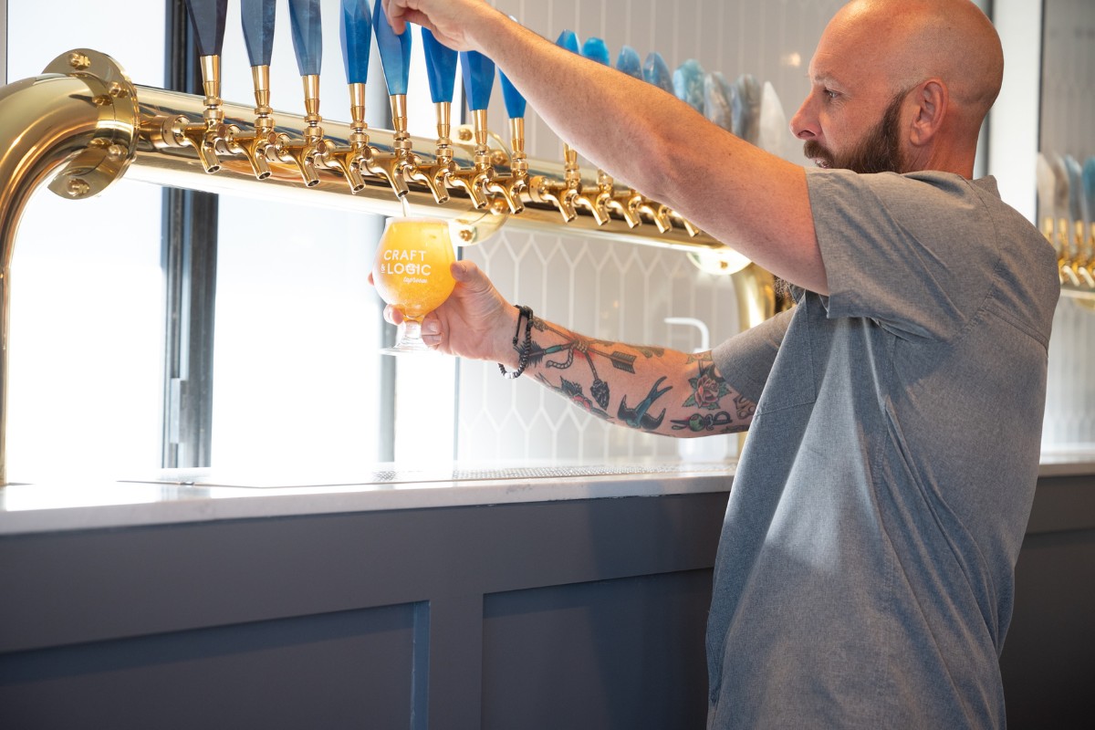 Bartender pouring a beer at Craft and Logic Taproom.