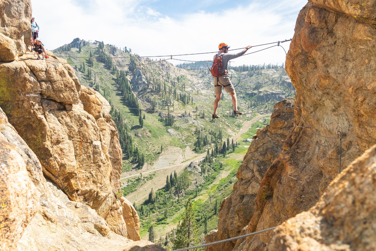 A climber traverses between rock faces on the Tahoe Via Ferrata.