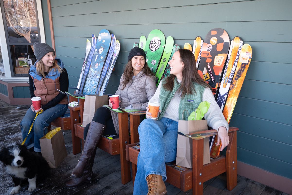 Women laughing in Adirondack chairs in downtown Truckee