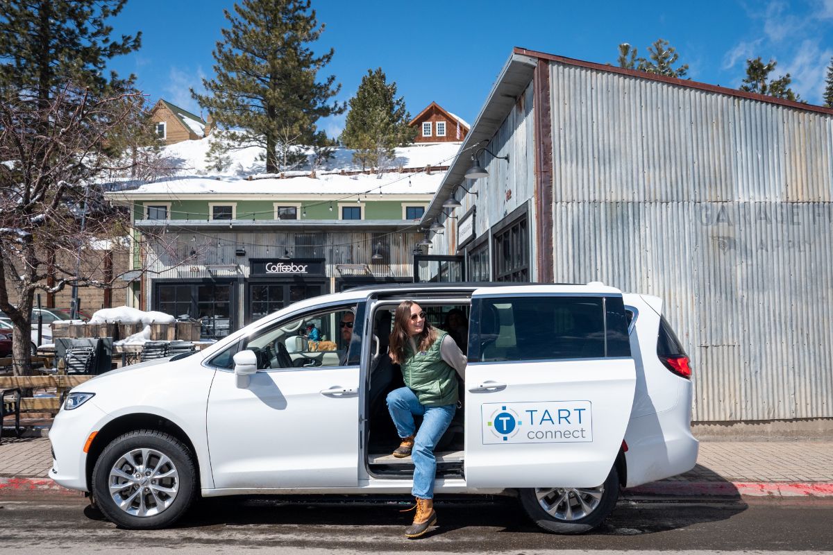 Woman getting off of Truckee's free shuttle - TART Connect. In downtown Truckee in front of Coffeebar.