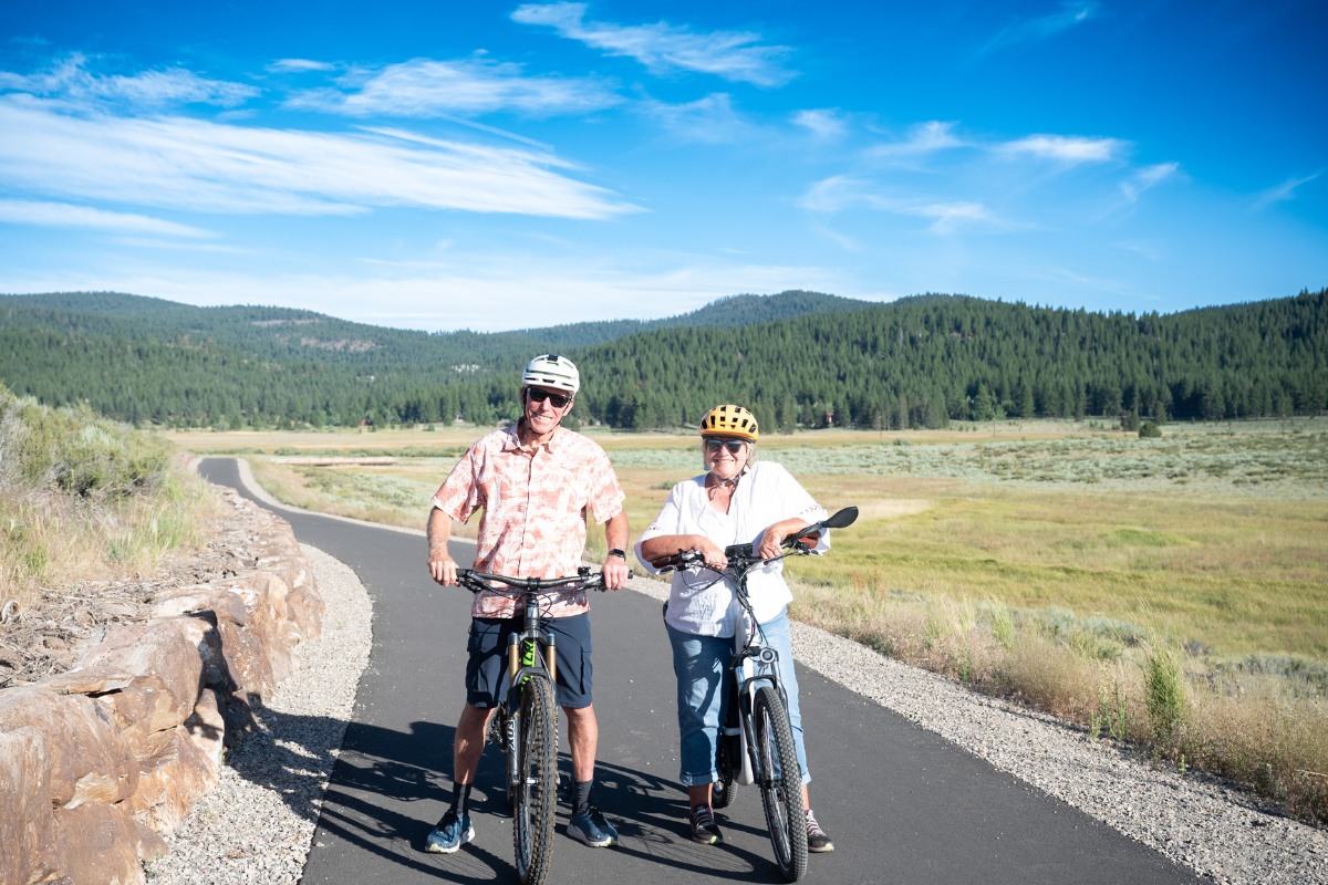 Smiling couple riding bikes on the Martis Valley Trail near Truckee.