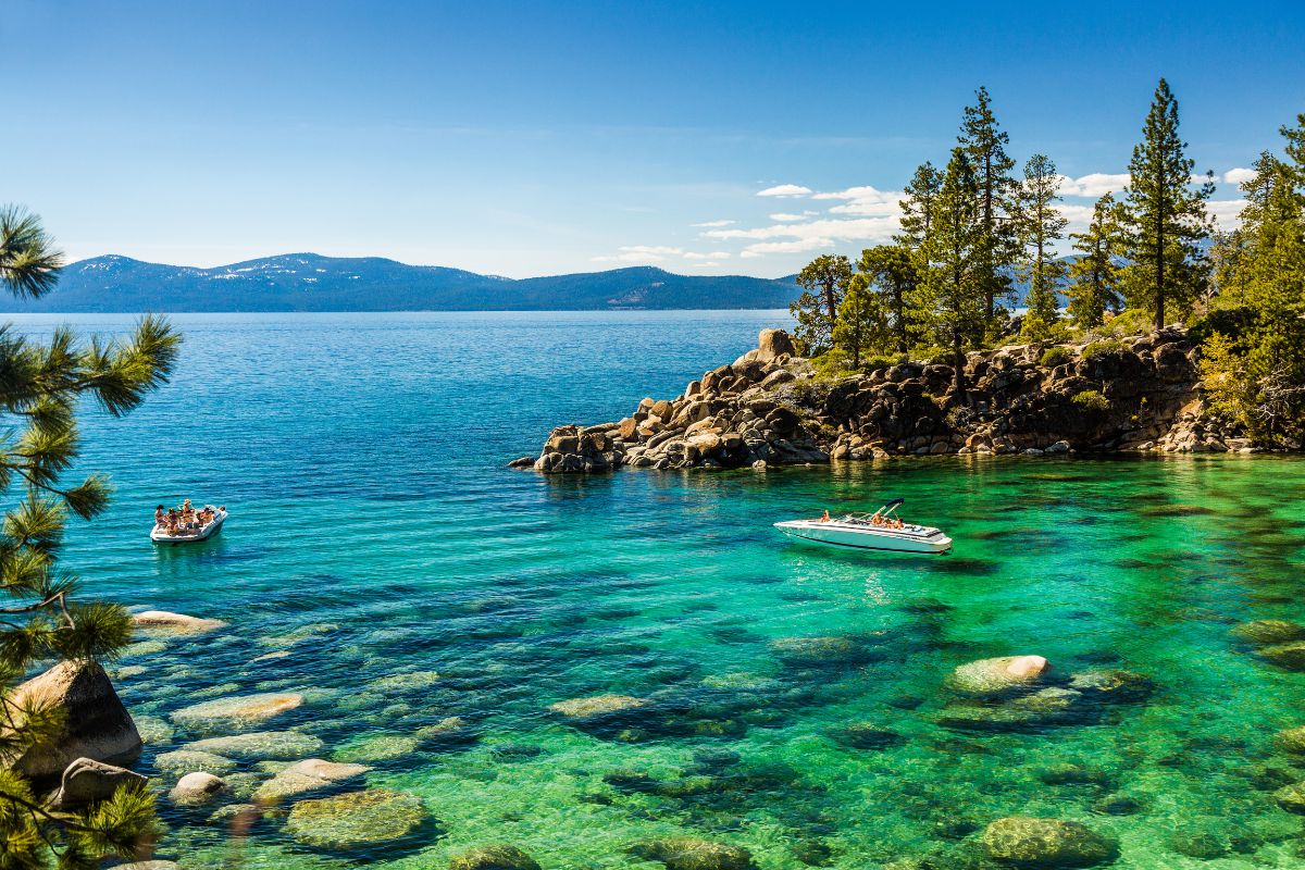 People boating in a North Lake Tahoe cove with mountains in background.