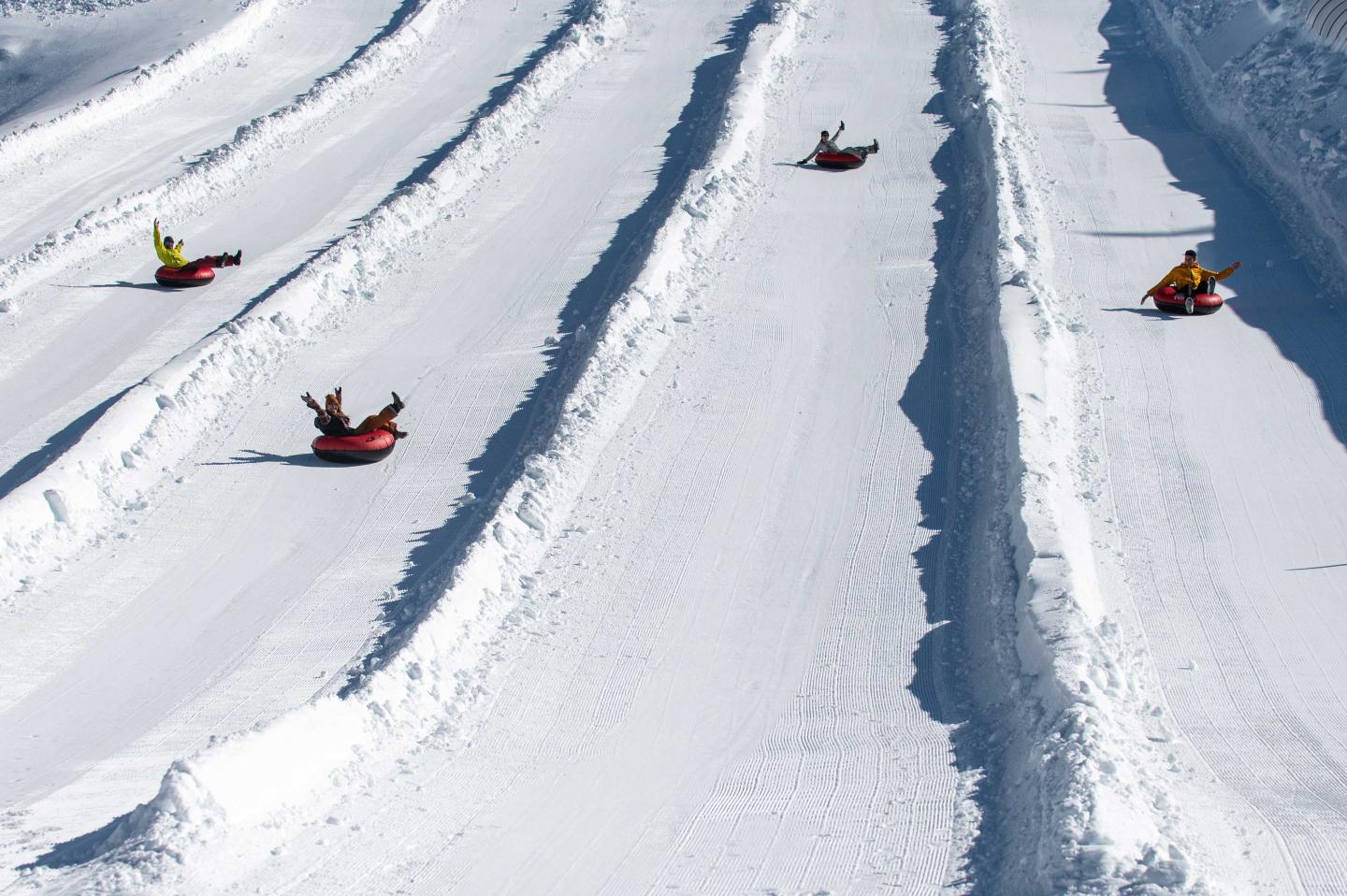 Snow tubes sliding down parallel snowy lanes.