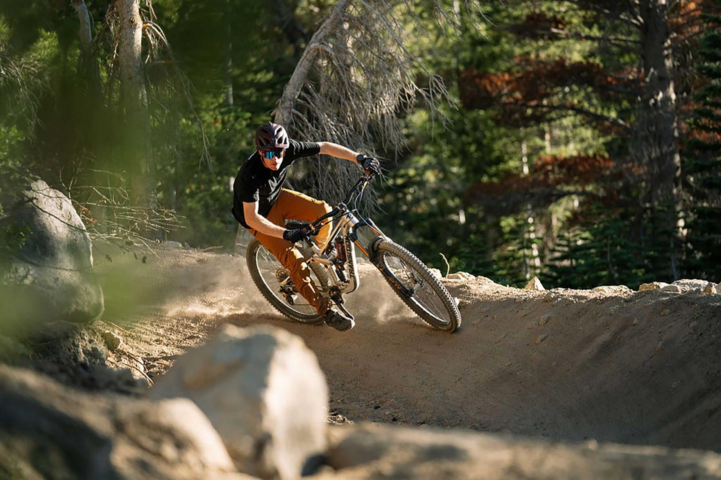 Mountain biker riding a dirt trail in a forest.
