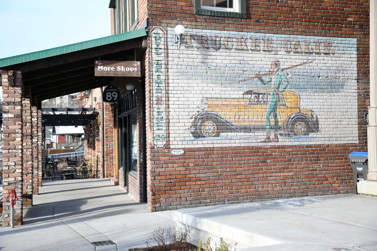 Brick building with vintage car mural on the wall.