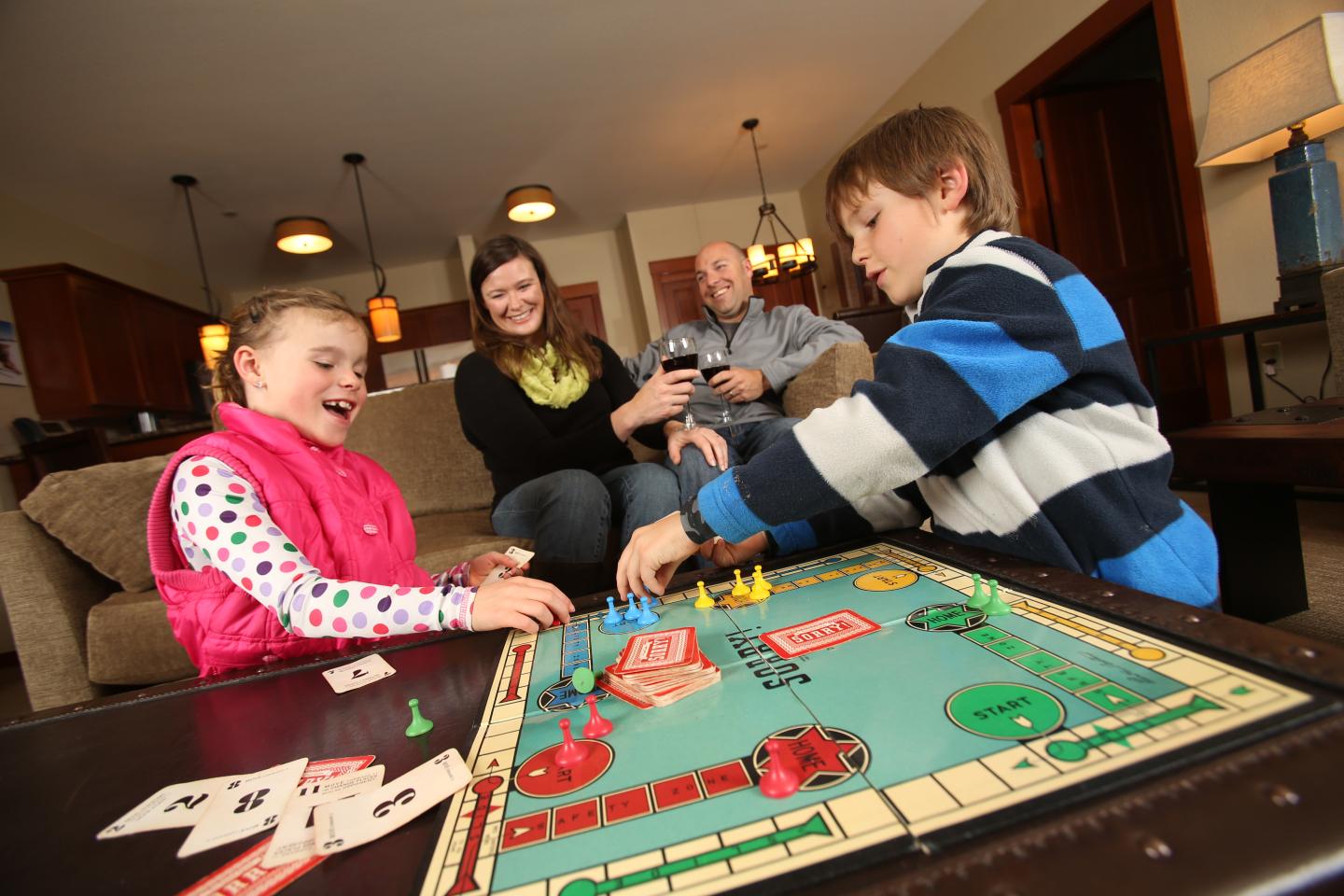 Family playing a board game in a cozy living room.