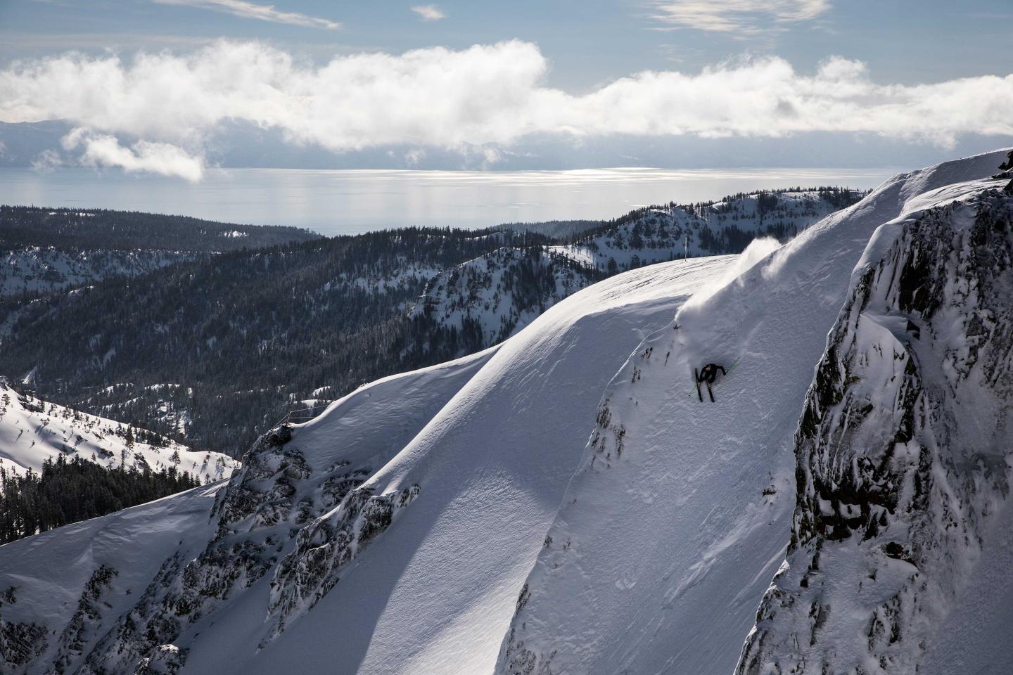 Snowy mountain ridge with distant clouds and a clear sky.