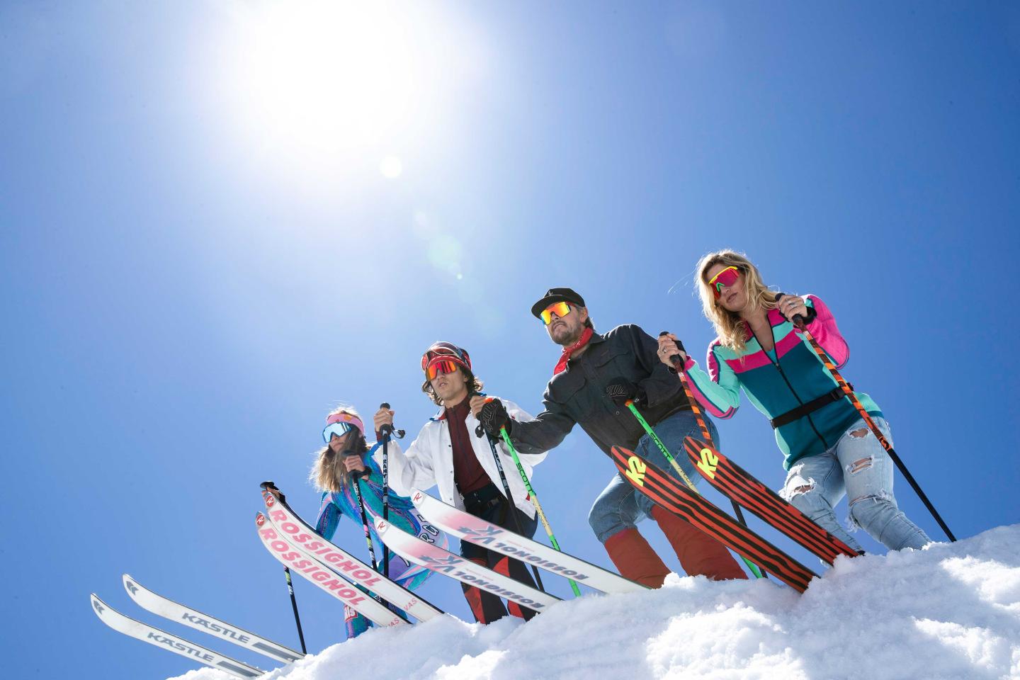 Group of skiers on a snowy slope under a clear blue sky.