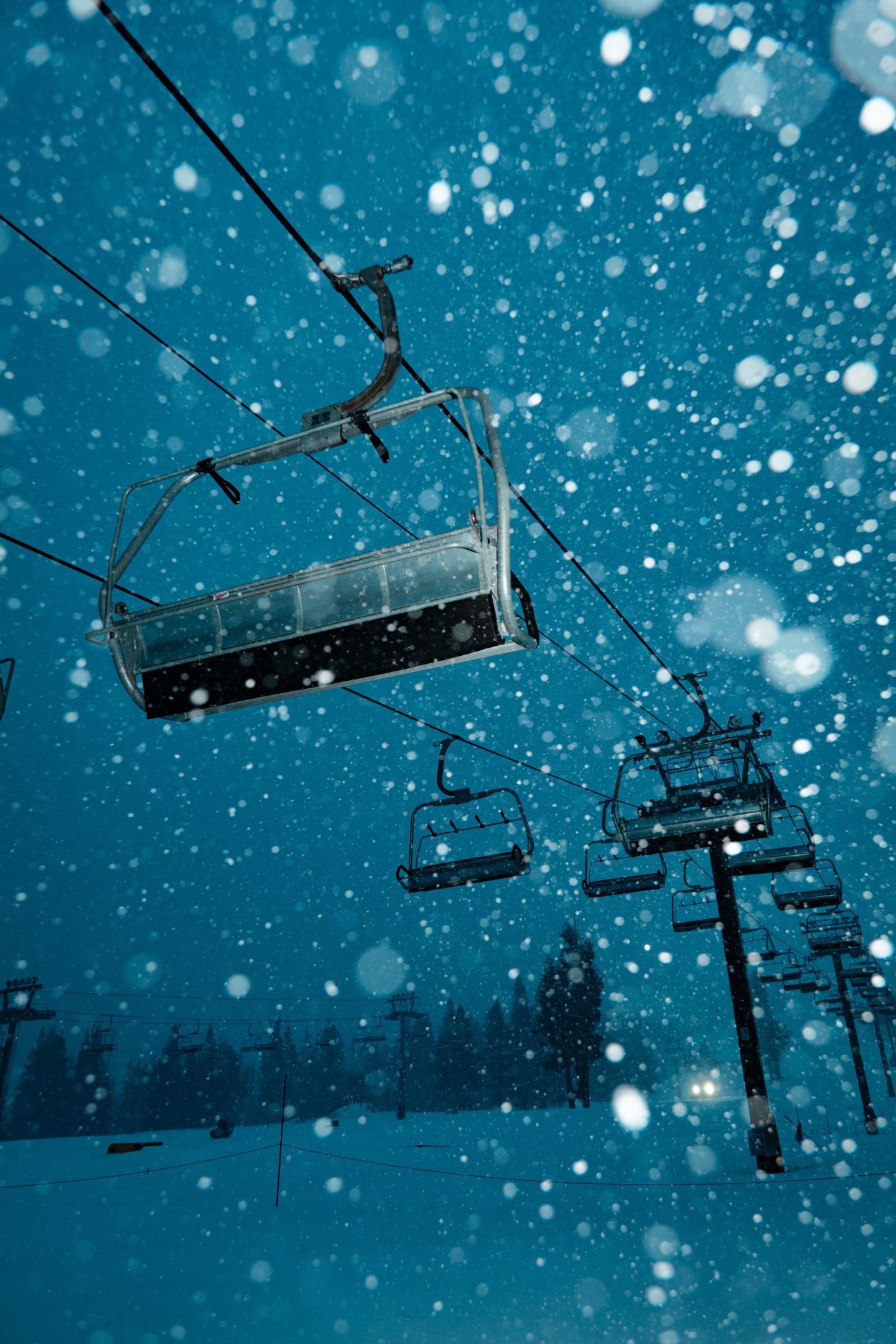 Ski lift in snowfall on a snowy evening.