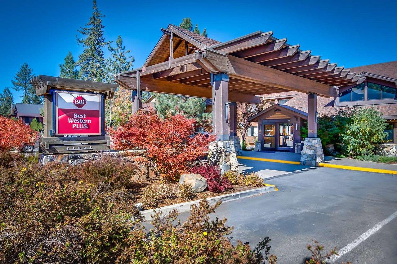 Hotel entrance with wooden canopy and landscaped garden.