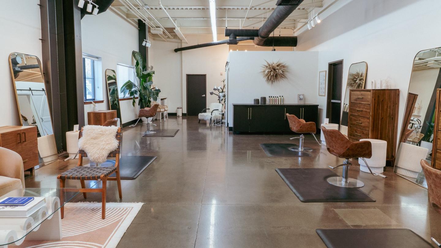 Modern hair salon interior with chairs, mirrors, and decor.