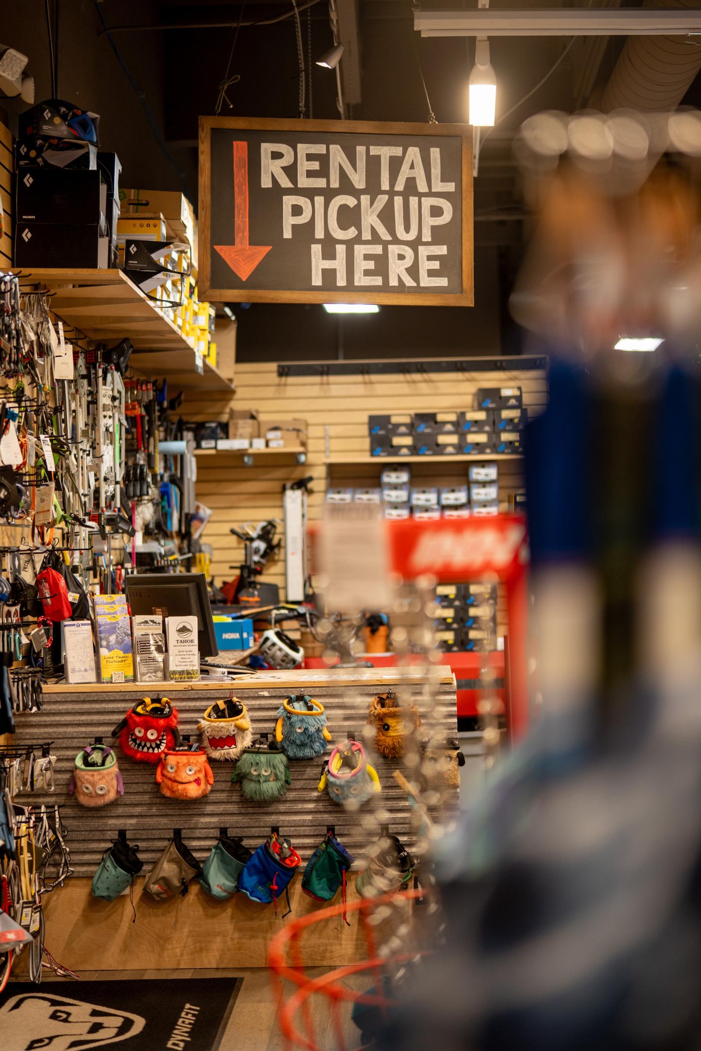 Sporting goods store interior with rental pickup sign and hanging helmets.