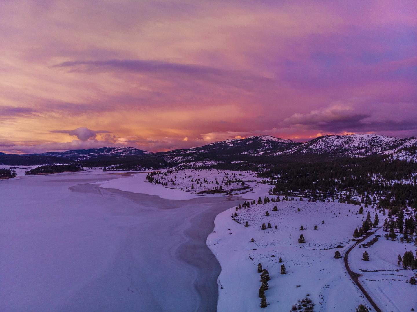 Boca Reservoir, Truckee, California, Snowy landscape with mountains at sunset, sky is pink and purple.