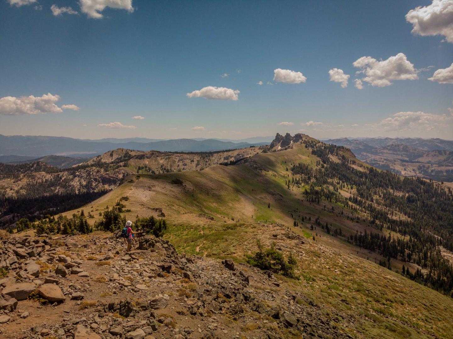 Mountain landscape with rocky path, blue sky, and scattered clouds.