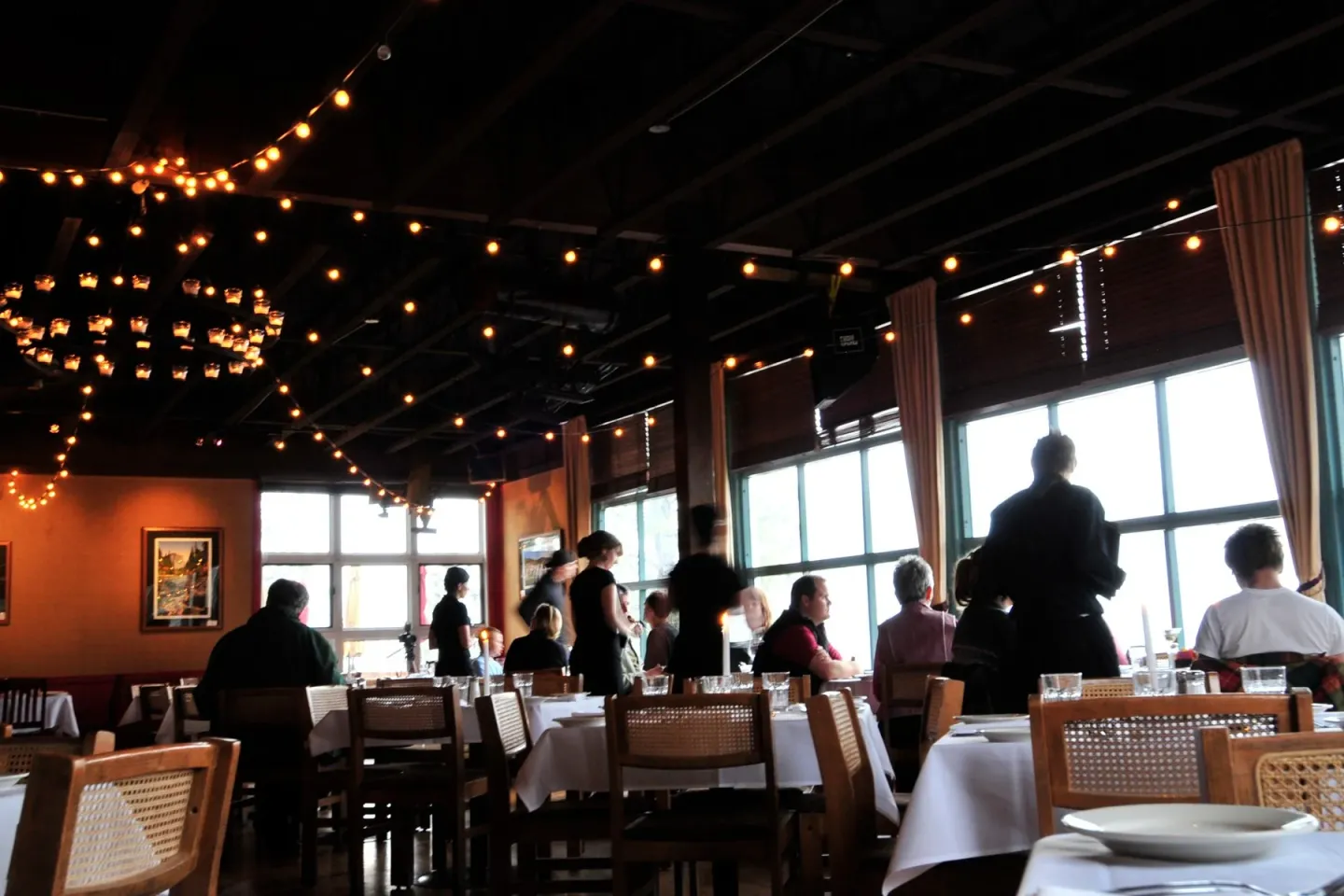 Cottonwood Restaurant Truckee / Dimly lit restaurant interior with hanging lights and people dining.