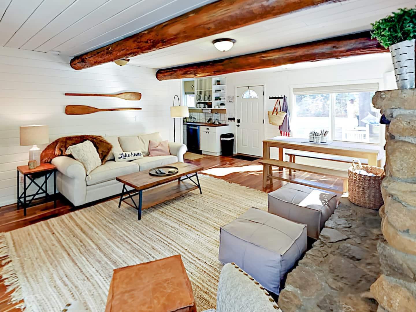 Cozy living room with a sofa, wooden beams, and a large window.