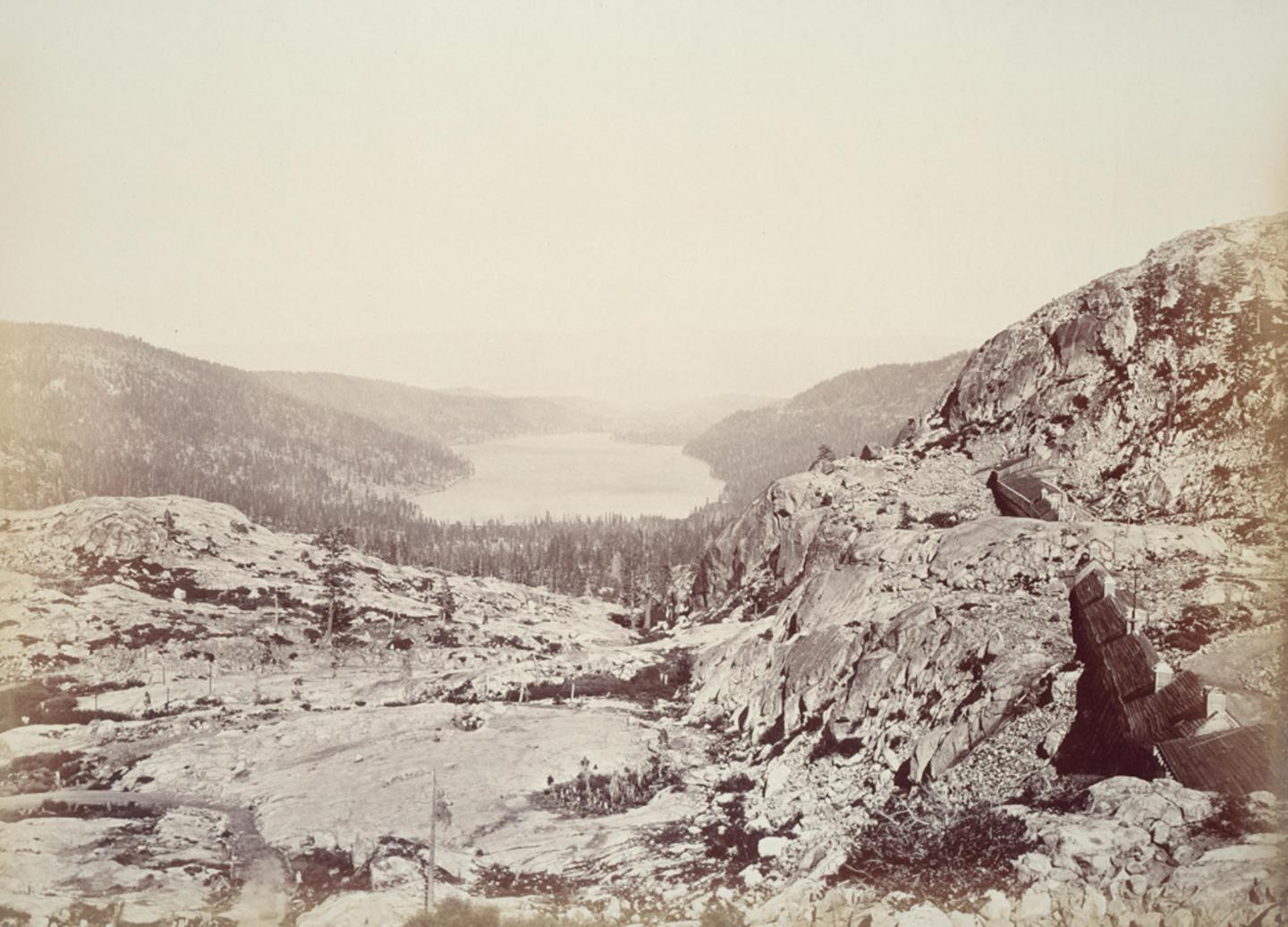 Historic photo of Donner Lake - Mountain landscape with a distant lake and rocky foreground.