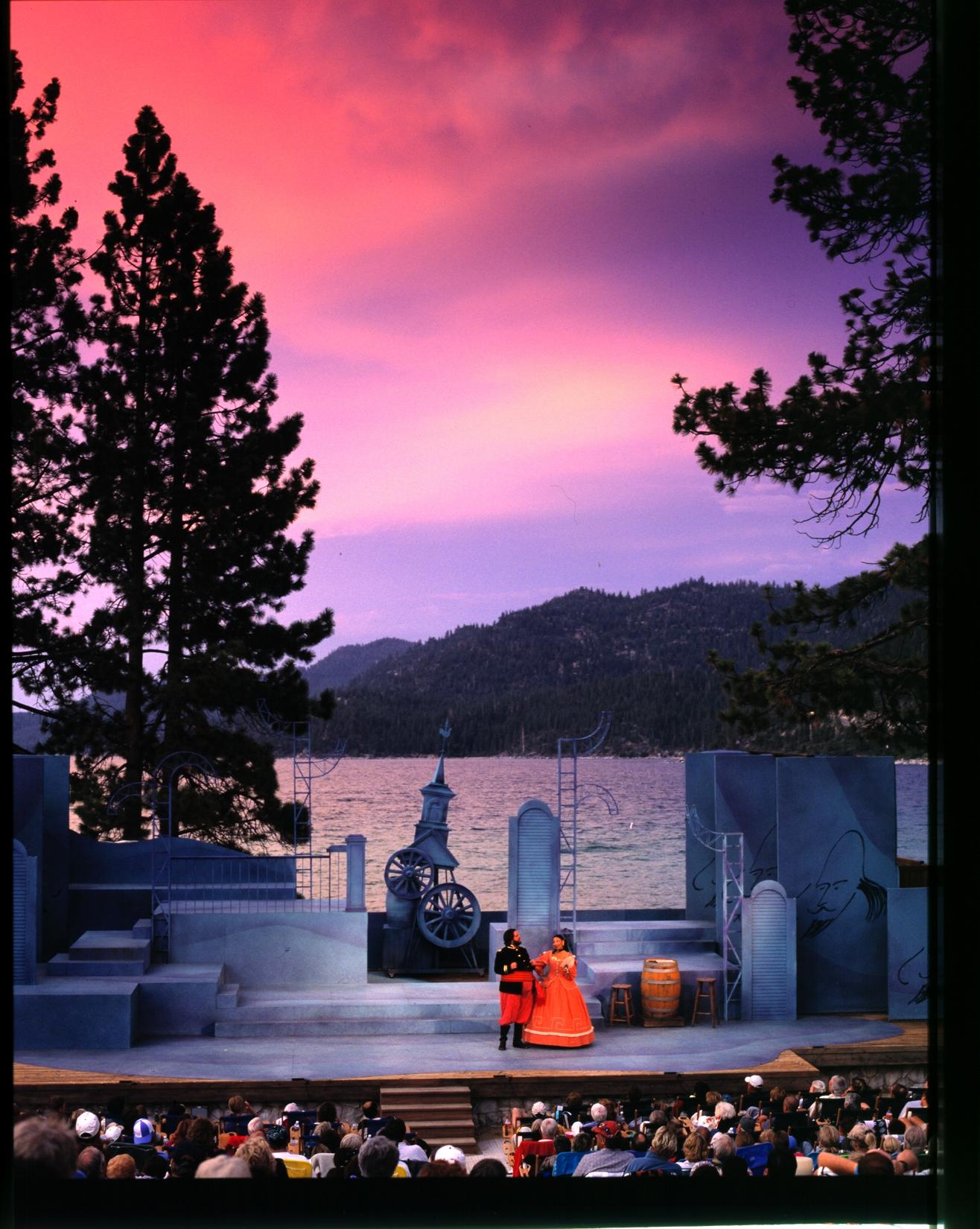 Outdoor theater at sunset with mountains and lake in the background. Shakespeare Festival Lake Tahoe