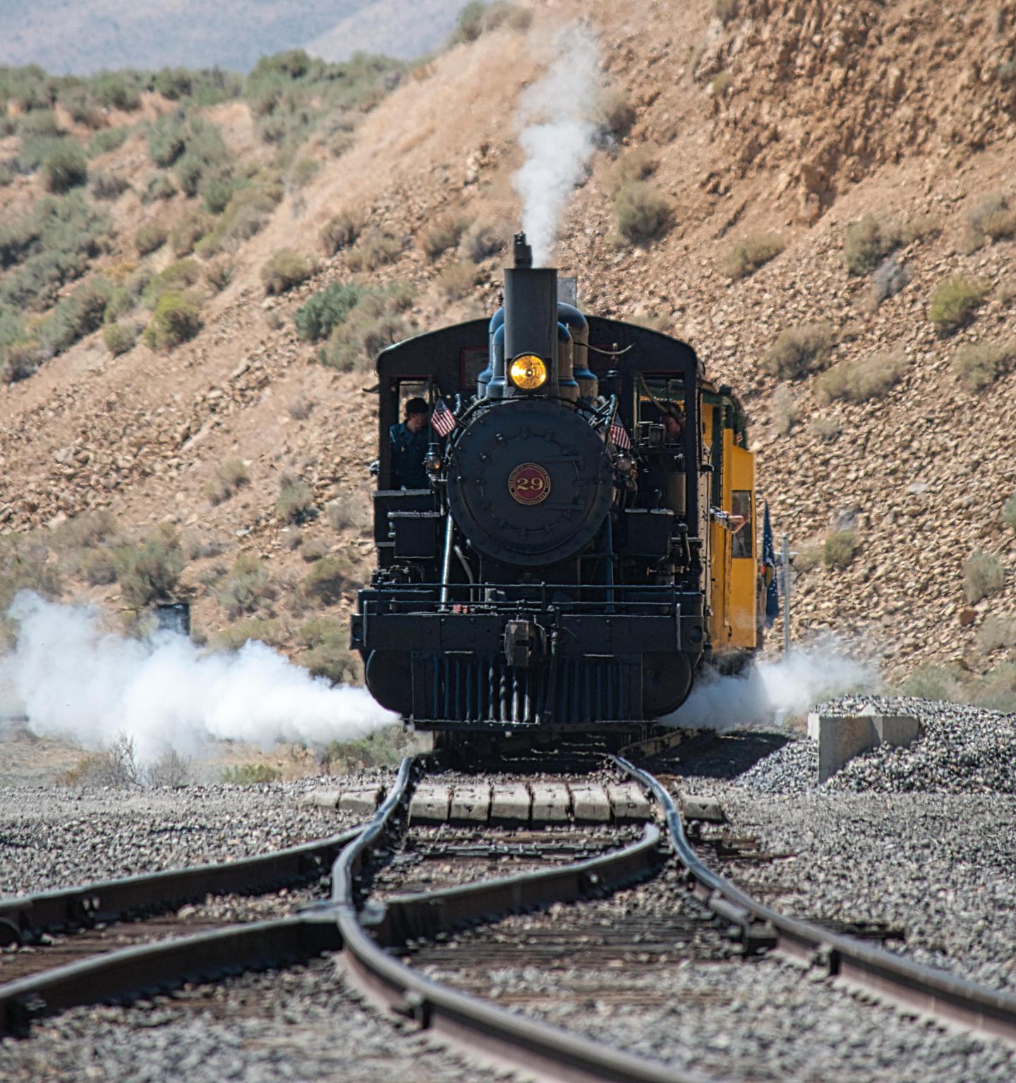Steam locomotive on a railway in a rocky desert landscape.