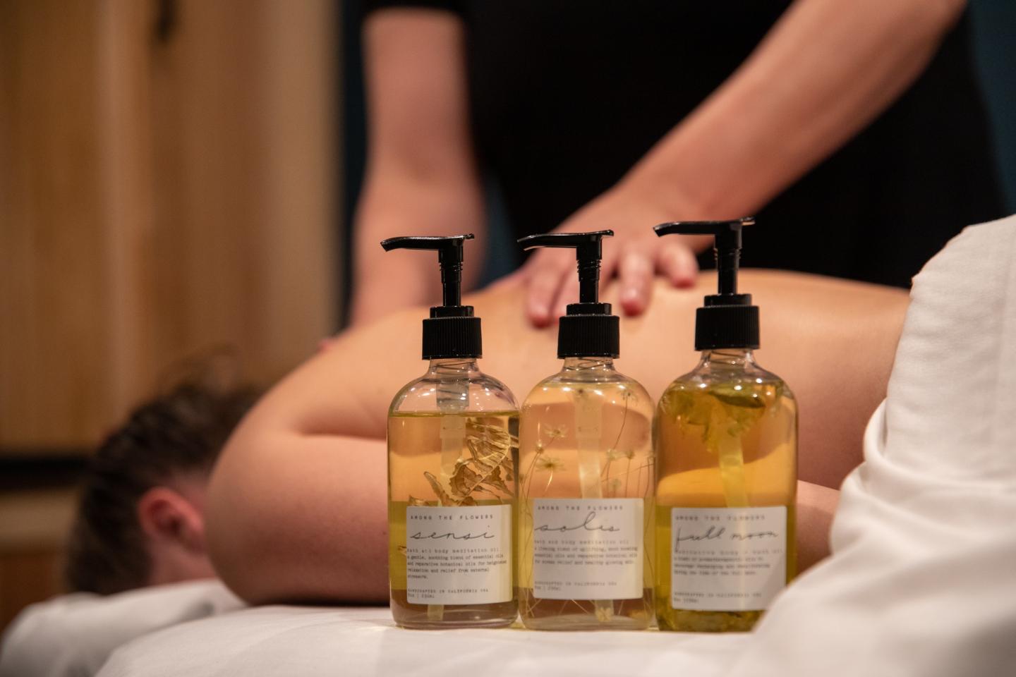 Martis Valley Massage / Massage bottles near person receiving a back massage.