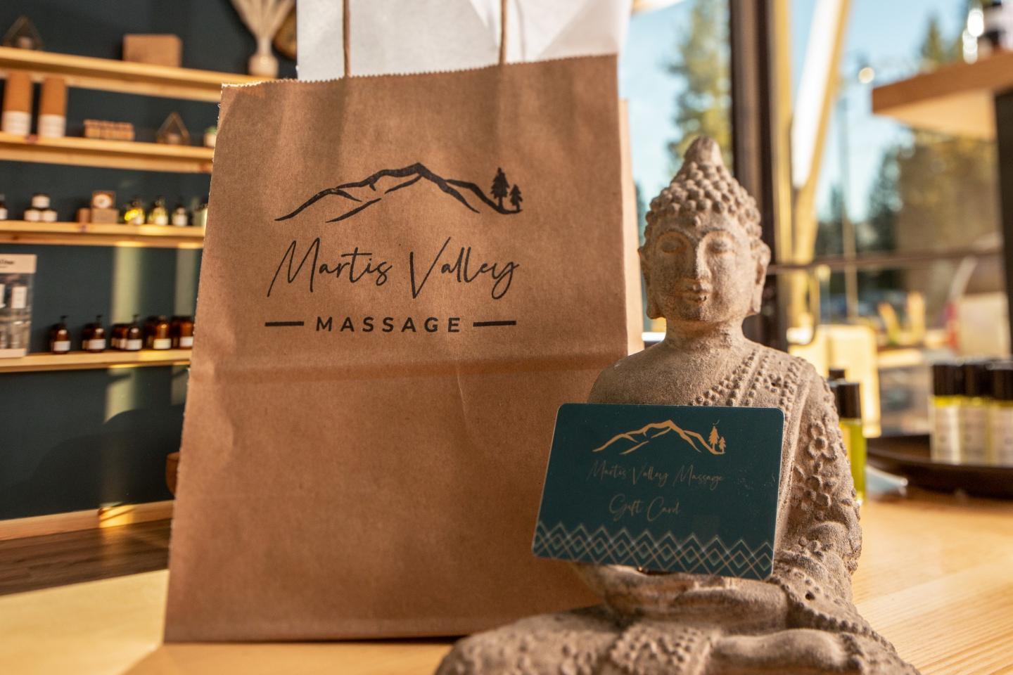 Martis Valley Massage // Buddha statue holding gift card beside massage gift bag.