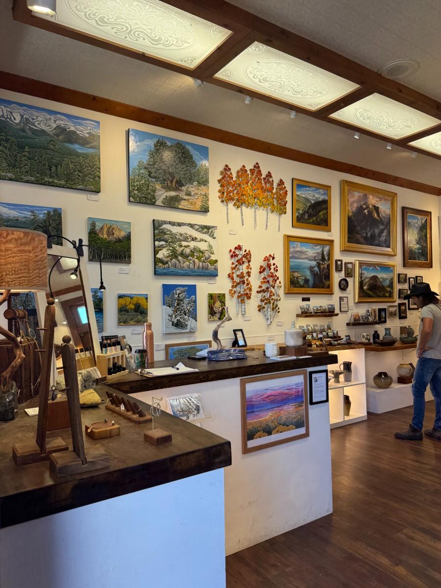 Mountain Arts Collective Downtown Truckee Art gallery interior with paintings on the wall and sculptures on tables.