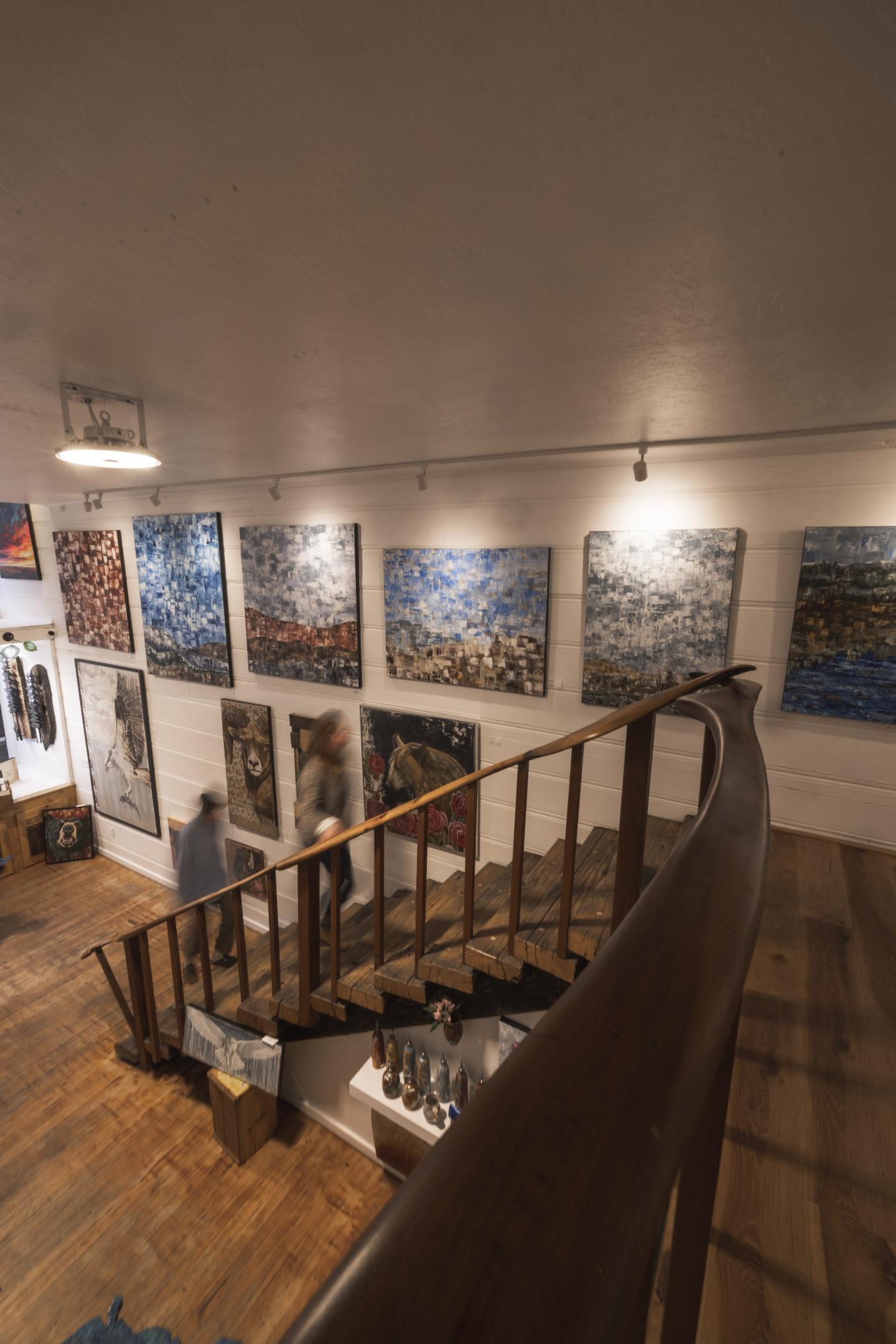 Art gallery with paintings on walls and a wooden staircase in Truckee California