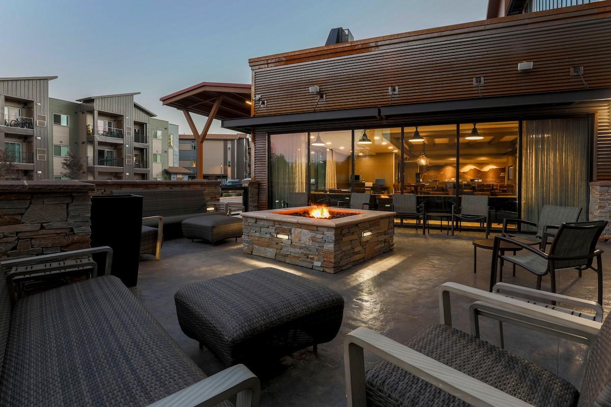 SpringHill Suites by Marriott Truckee Lake Tahoe - Outdoor patio with modern seating and a lit fire pit at dusk.