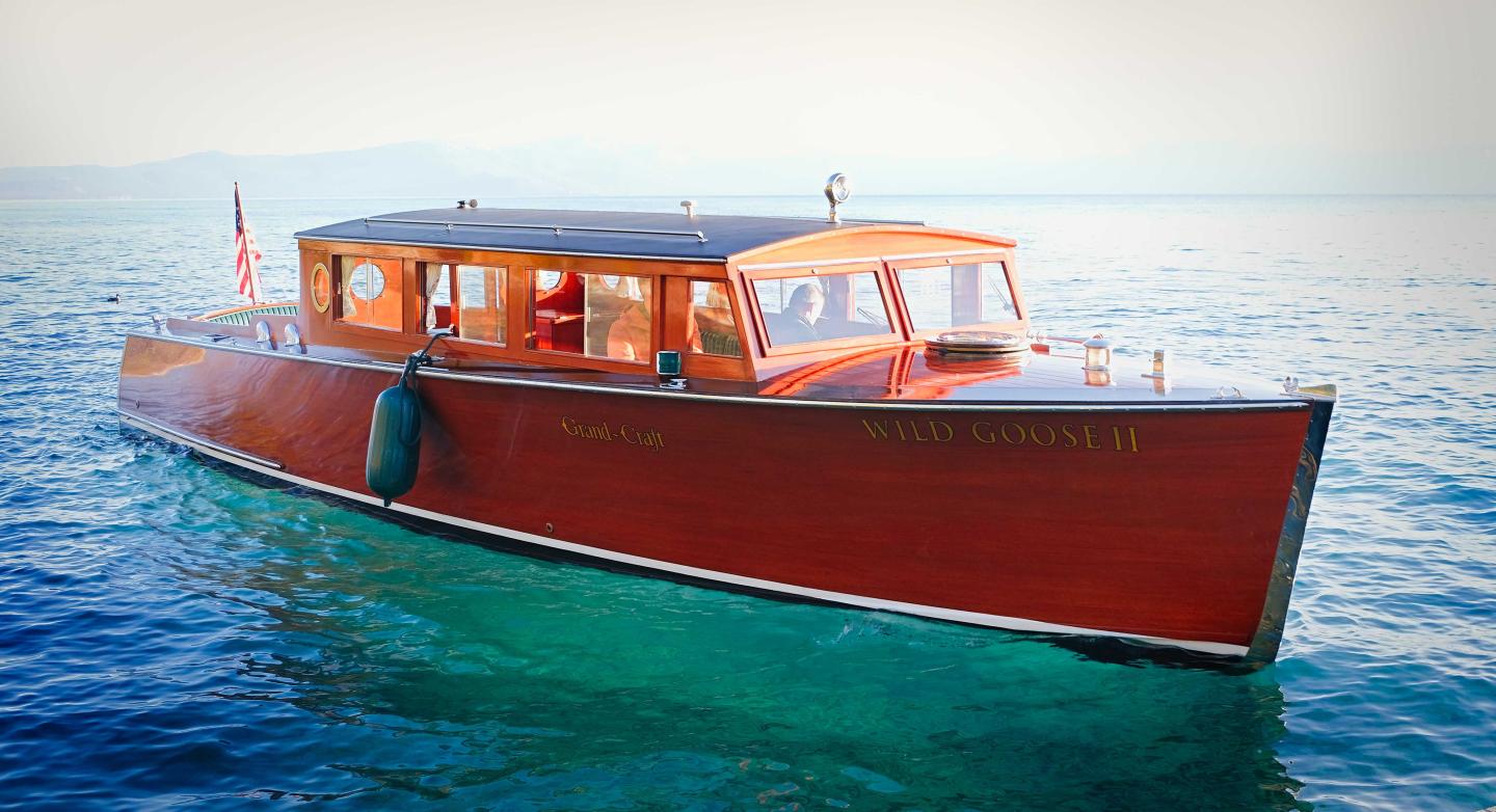 Wooden boat on calm blue water with a sunlit cabin.