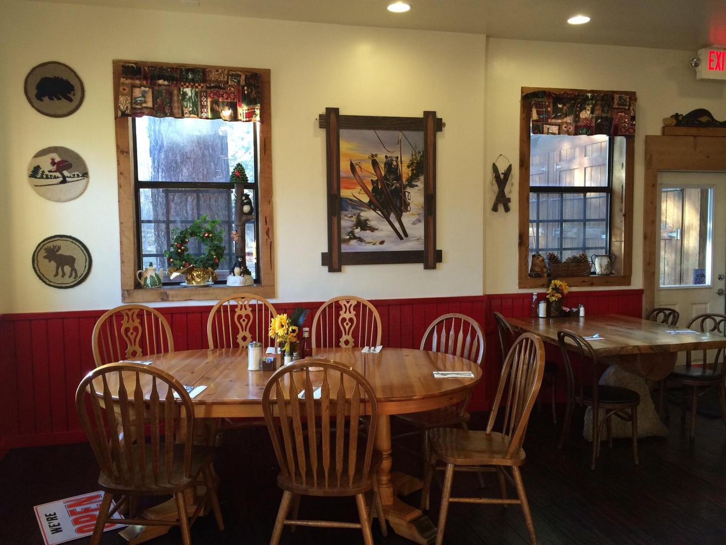 Cozy restaurant dining area with wooden tables and chairs, Western-themed decor.