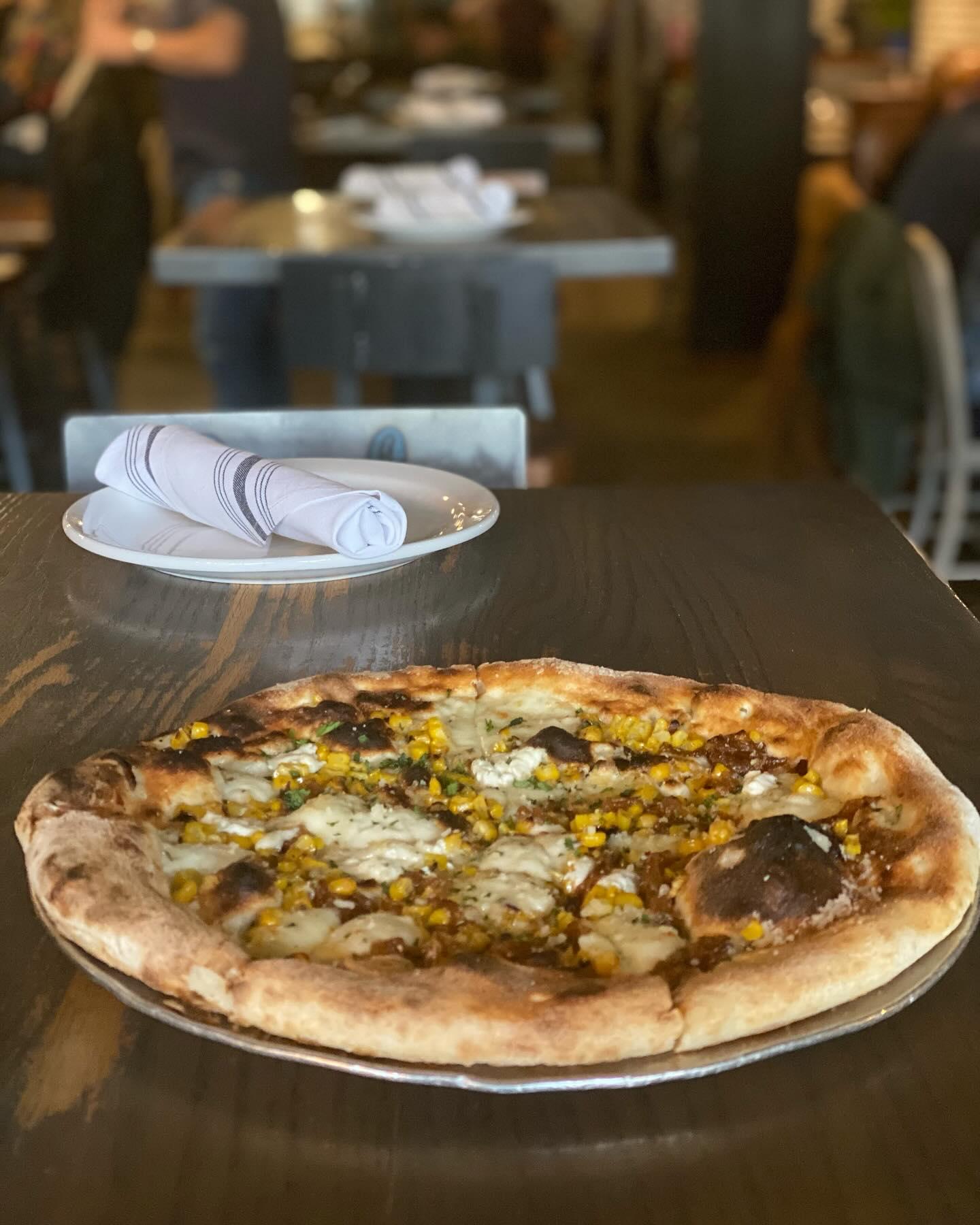 Pizza with various toppings on a restaurant table.