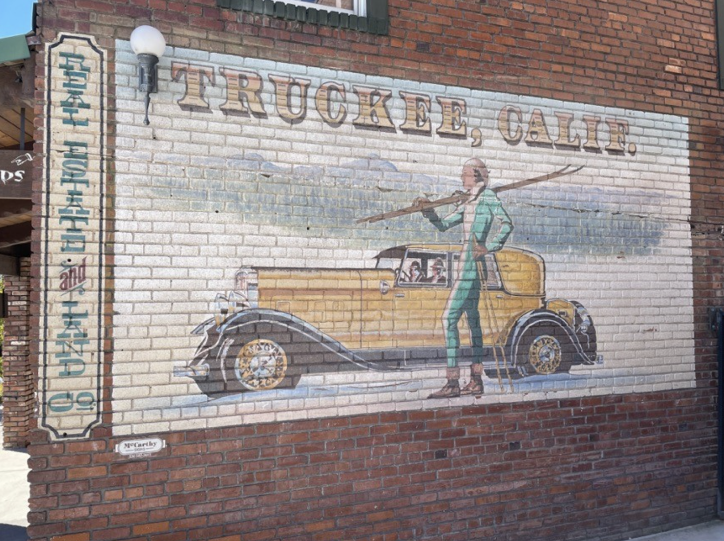 Mural of a classic car and man in green holding skis, with "Truckee, Calif." text.