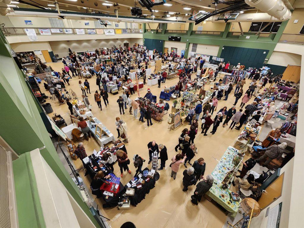 Crowded indoor market with various stalls and shoppers.