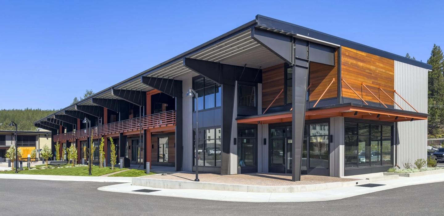 Modern building with wood accents and large windows under a clear blue sky.