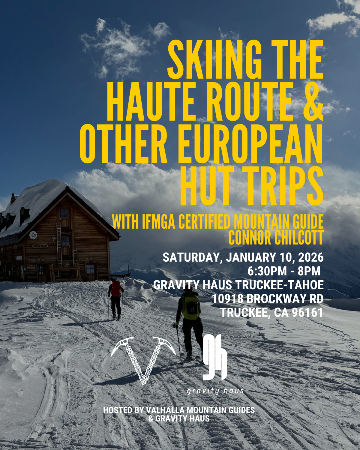 Snowy mountain hut with skiers under a bright blue sky.
