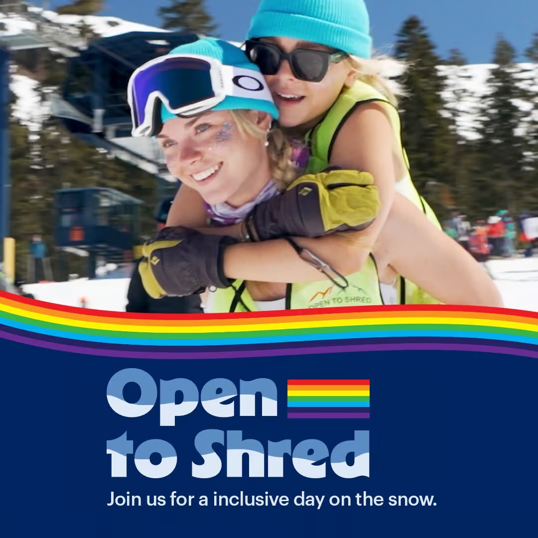 Two happy snowboarders, one giving a piggyback ride, wearing winter gear and sunglasses.