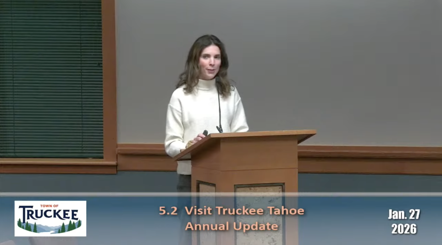 Woman speaking at a podium during a meeting presentation.