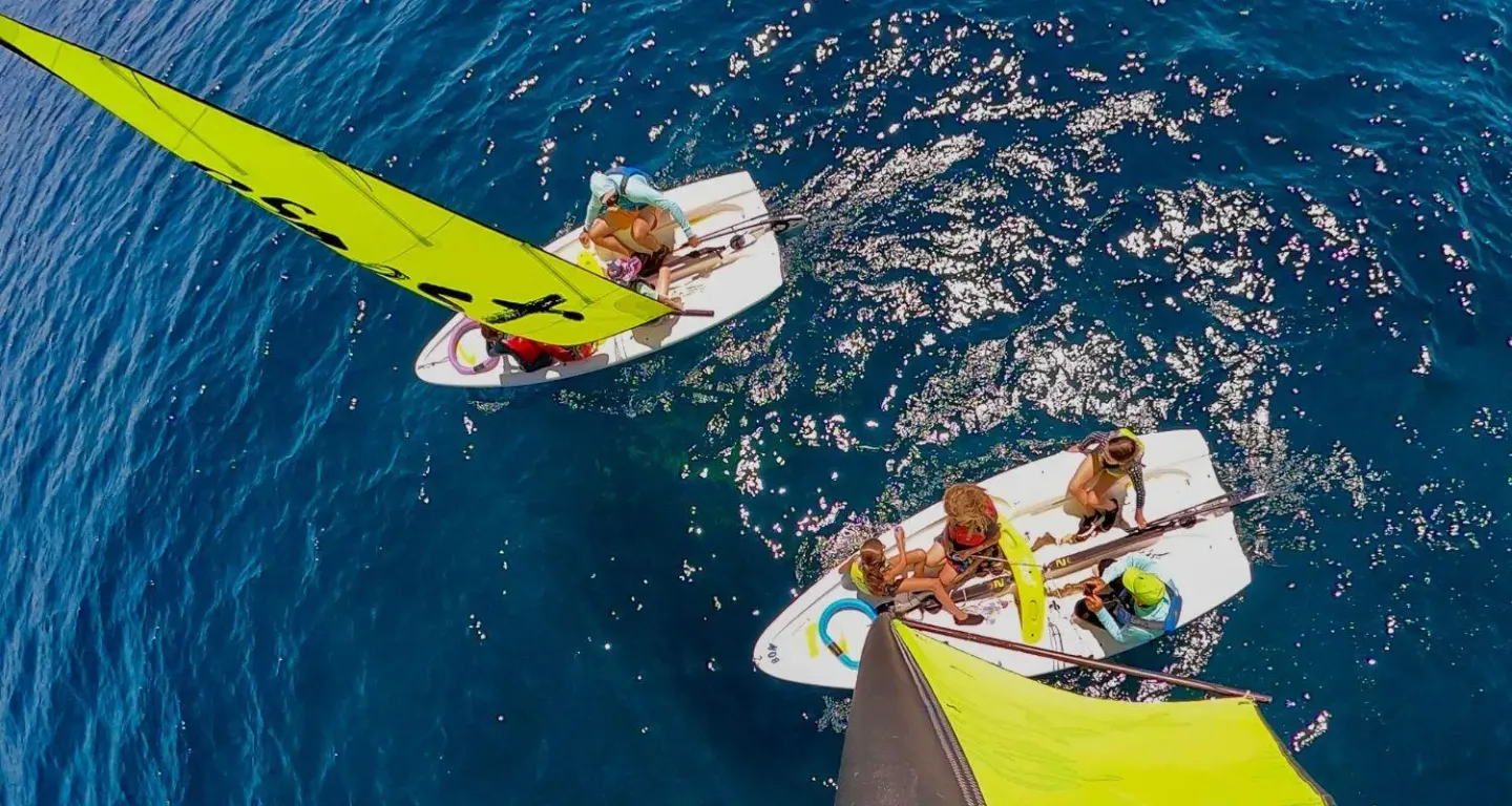 Sailboats with bright sails on a sunny blue sea.