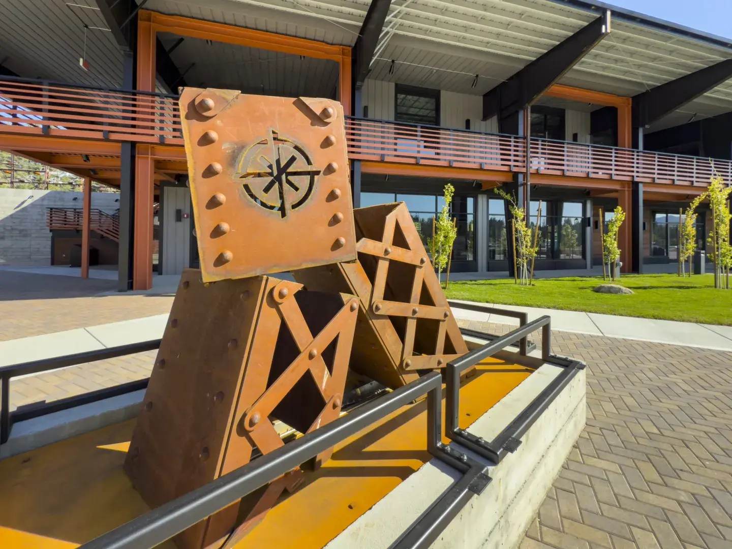Geometric metal sculptures in front of a modern building.