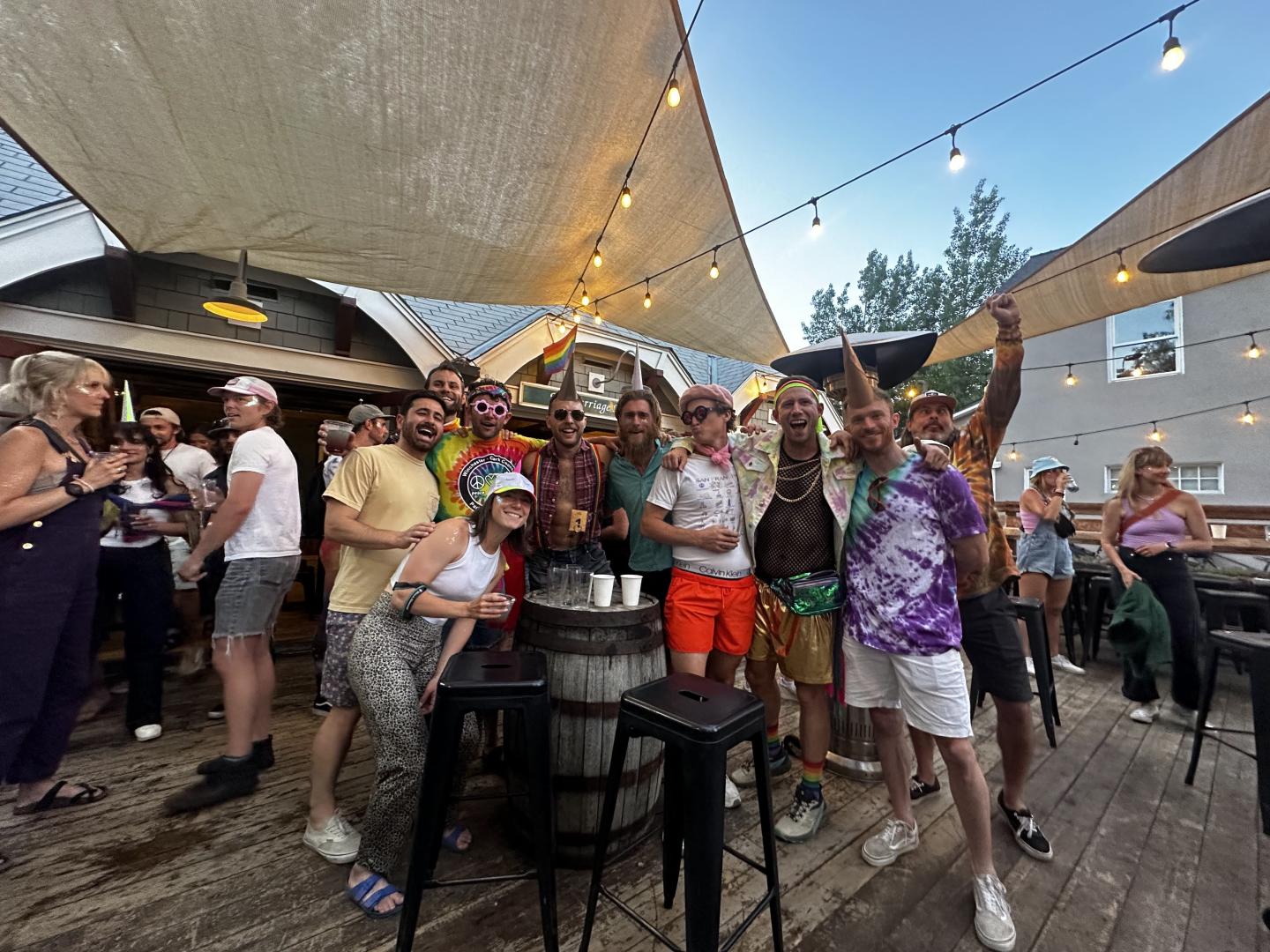Group of people celebrating at an outdoor venue with string lights.