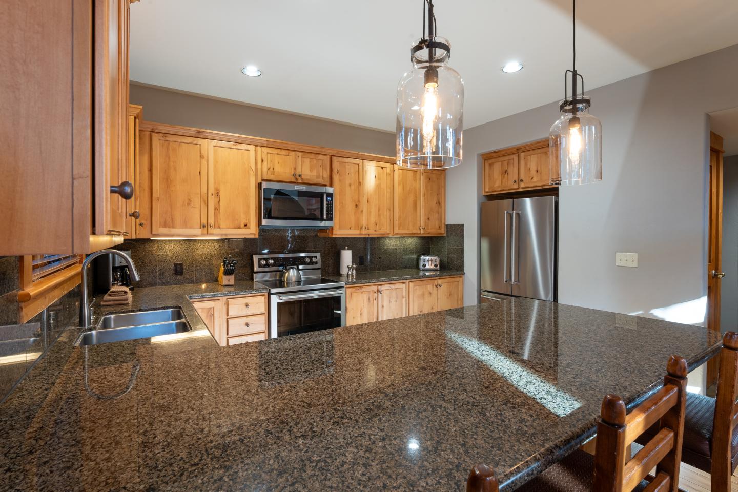 Spacious kitchen with wooden cabinets, granite countertops, and stainless steel appliances.
