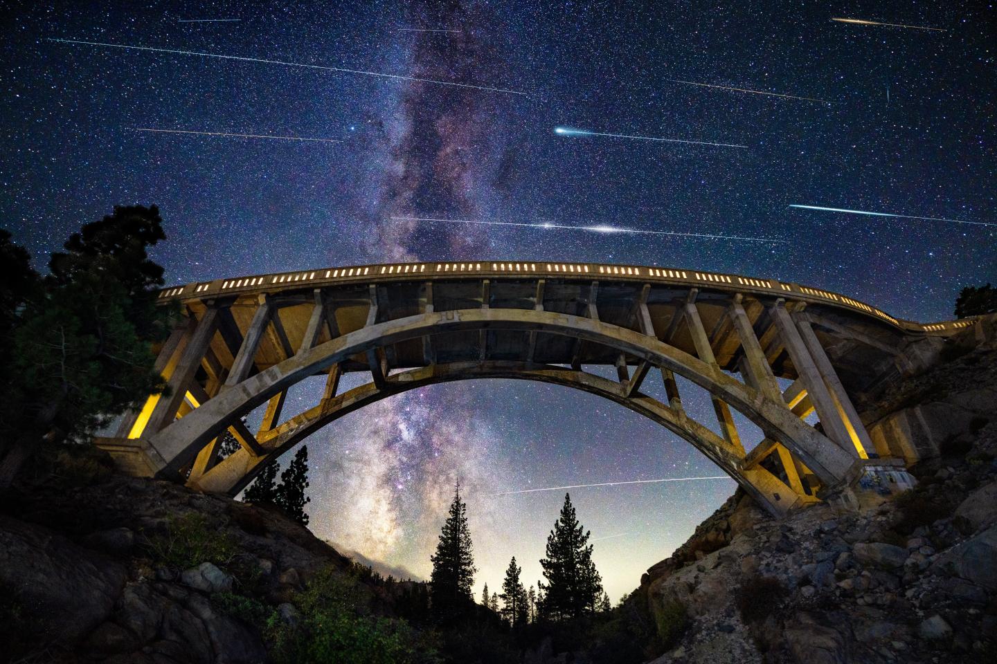 Bridge against a starry night sky with visible Milky Way.
