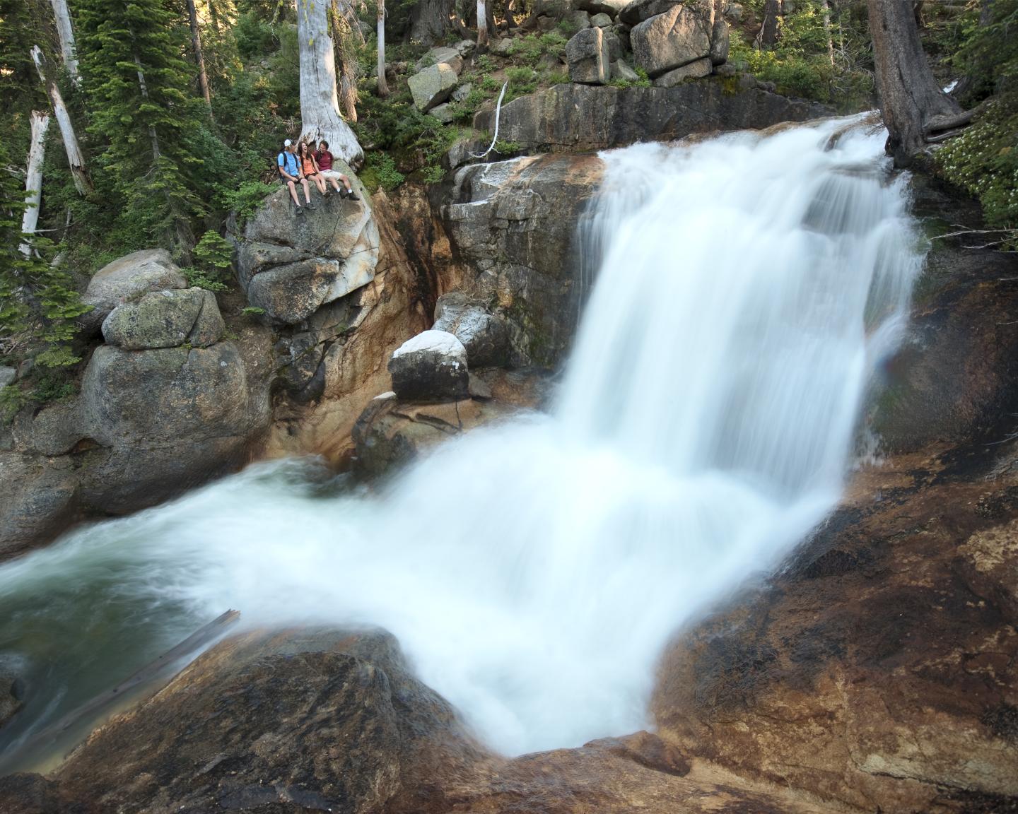 Waterfall cascading over rocks in a forest setting.
