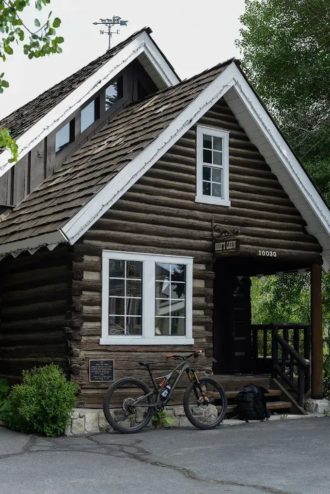 Rustic log cabin with a parked bicycle in front.
