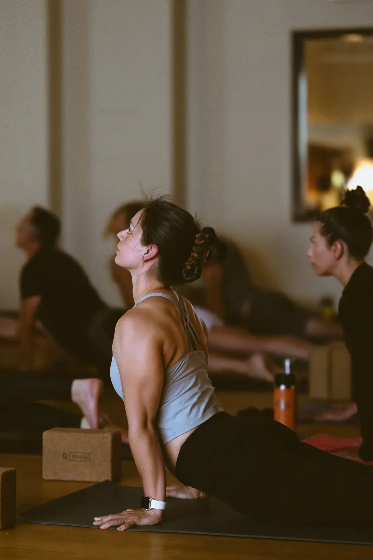 People practicing yoga indoors, focused on poses.