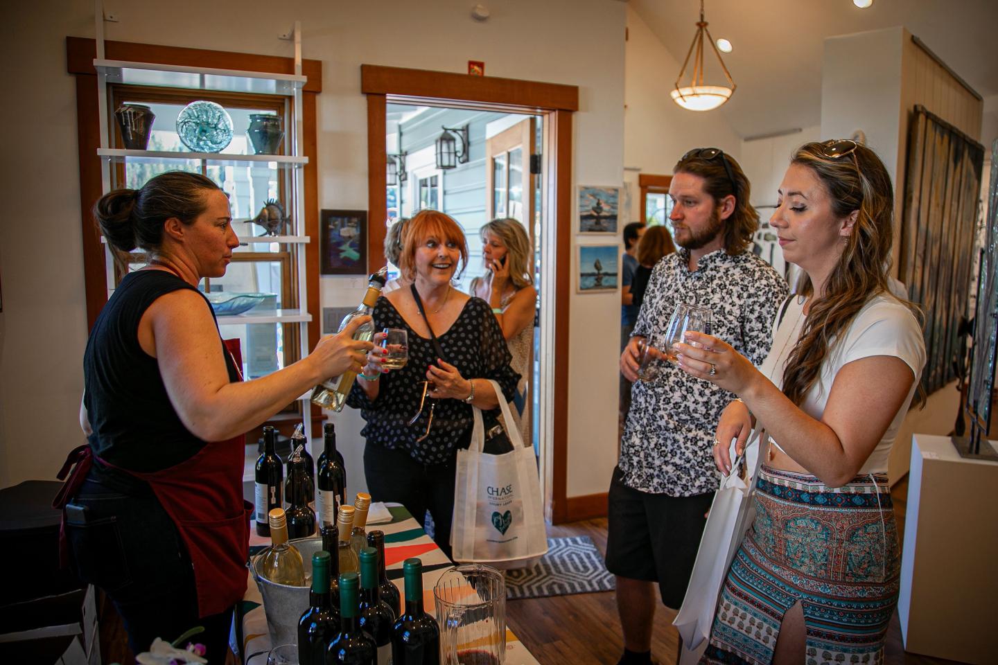 Wine tasting event with four people in a cozy indoor setting.