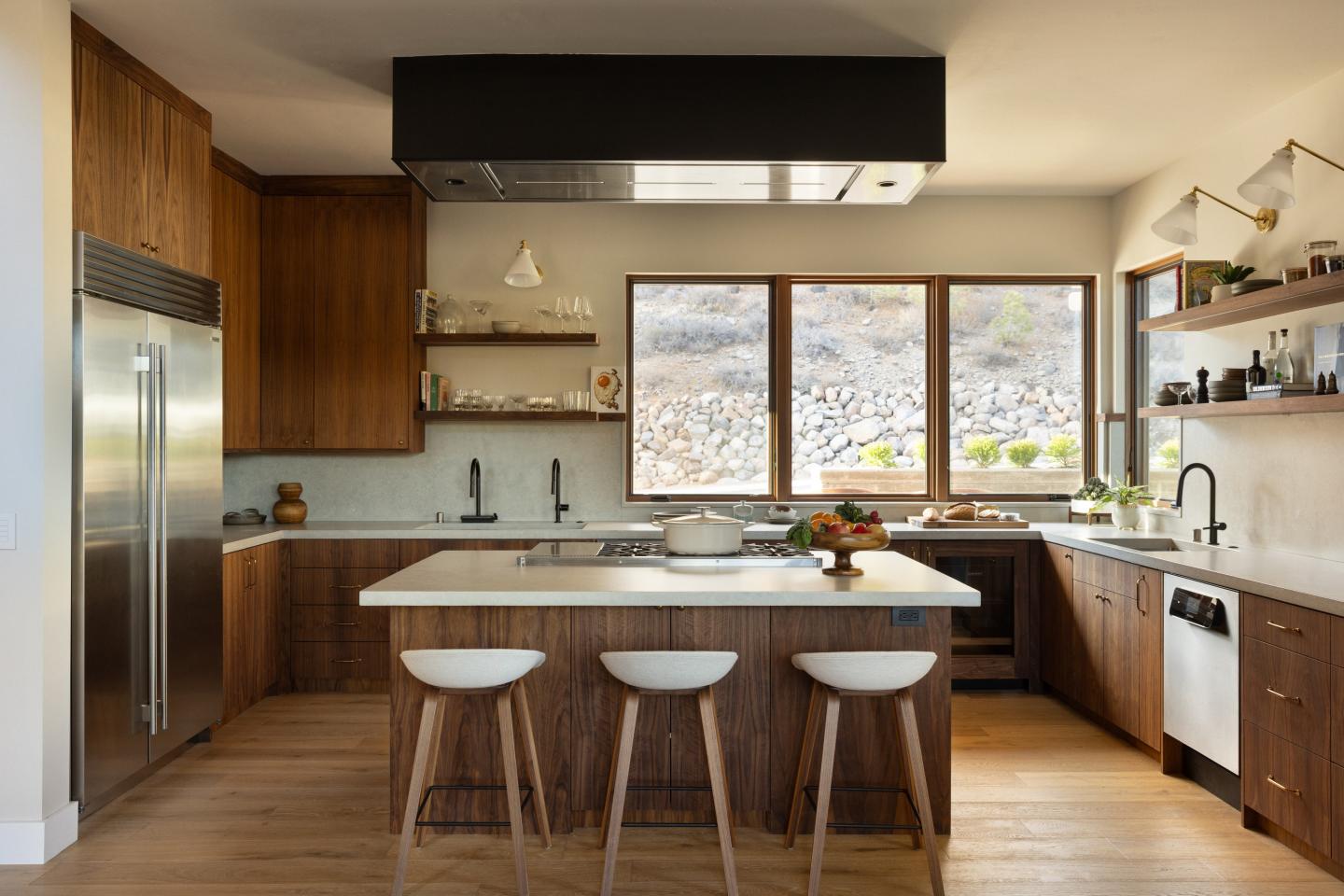 Modern kitchen with wooden cabinets, island, and large windows.
