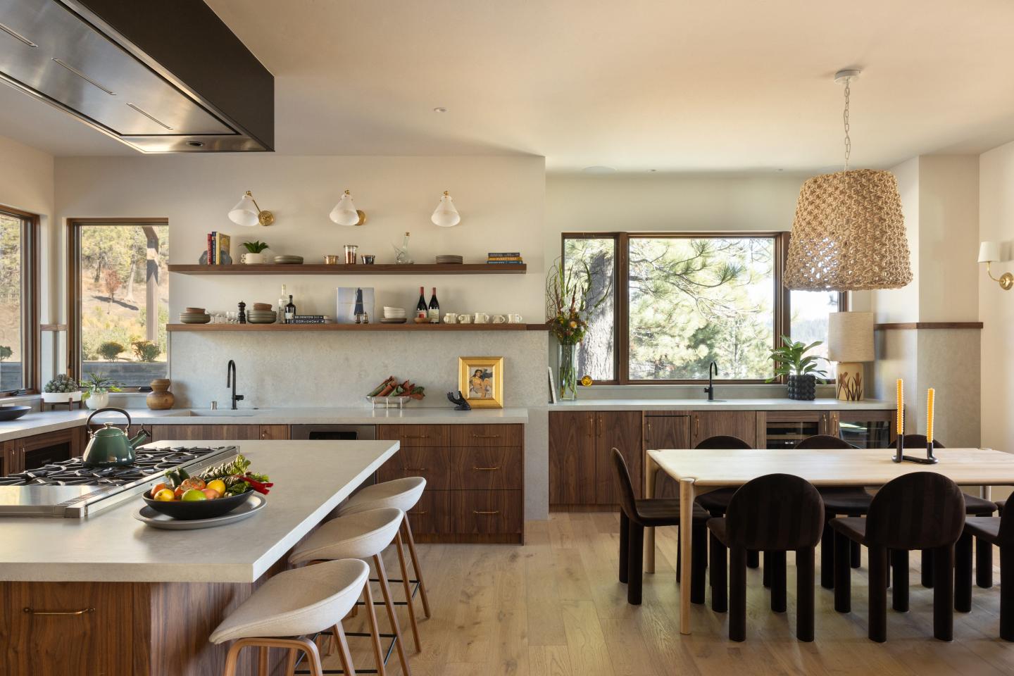 Modern kitchen with wooden cabinets, white countertops, and a dining table for six.