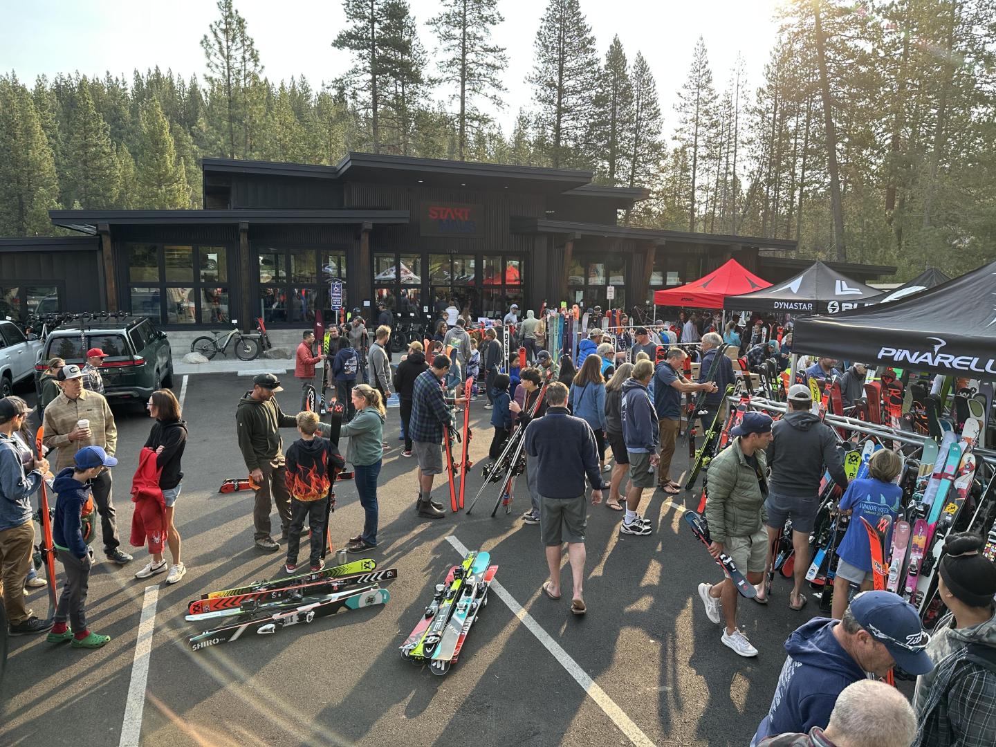 Crowd gathered at outdoor ski sale with gear and tents.